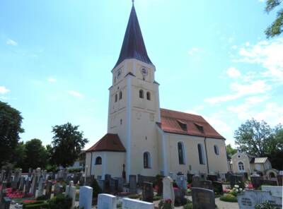 Kirche umgeben von Grabsteinen mit blauem Himmel