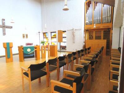 Besucherstühle, ein Altar und eine Orgel stehen in der Kirche