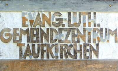 Schriftzug auf der Mauer: Evang.- Luth.-Gemeindezentrum Taufkirchen